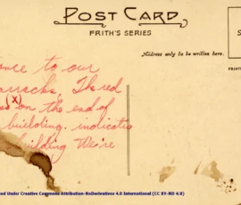 Artifact 1940-08-01-a - Postcard of Warburg Barracks Calvary Gates, sent from Aldershot, England, United Kingdom - Postcard, Reverse. Annotation: "Entrance to our barracks. The red cross (x) on the end of one building indicates the building We're in."